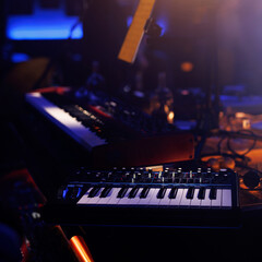 A close-up view of a music synthesizer keyboard with dials and switches