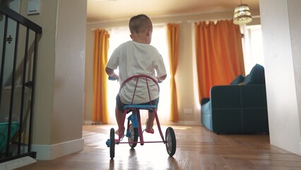 Child learns to ride a bike. happy family kid dream bicycle concept. kid is riding a bike indoors....