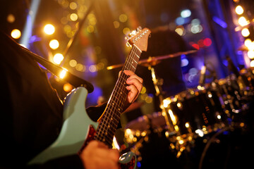 A guitarist plays a chord on an electric guitar during a rock band performance