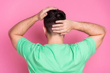 Rear view photo of unknown satisfied guy with beard dressed green t-shirt hands touching new haircut isolated on pink color background