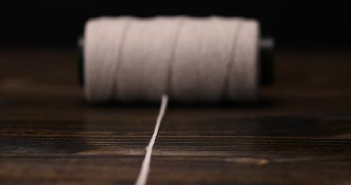 white cotton thread wound on a tube , thin cotton thread for use in cooking