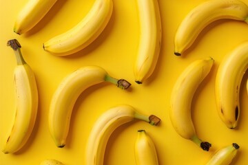 Fresh bananas on vibrant yellow background, top view flat lay concept for healthy eating and nutrition inspirations