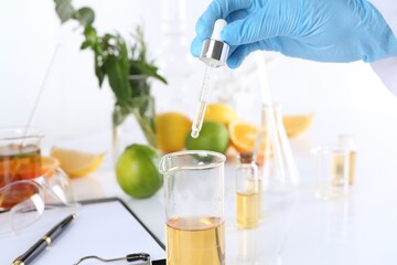 Aromatherapy product. Scientist developing essential oils at white table in laboratory, closeup