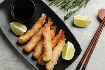Delicious breaded fried shrimps served on grey table, flat lay