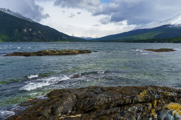 From the rocky shores of Tierra del Fuego National Park, you can see the waters of the Beagle Channel, forests and  Andean mountains. Ushuaia - Argentina