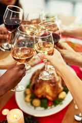 Christmas, food and friends toast with alcohol for dinner party, celebration and festive event with wine. Family, home and people cheers at feast, lunch and meal for holiday, eating or Thanksgiving