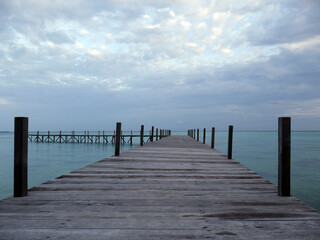 tropical beach with turquoise waters with wooden pier