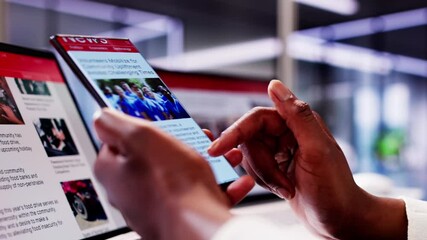 African American Woman Reading Online News on Smartphone and Laptop: Keeping Up