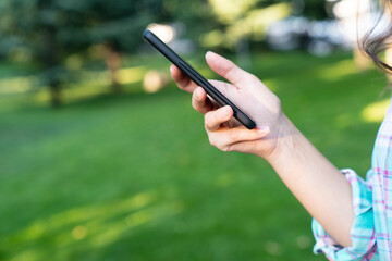 woman using phone. Happy young woman using smart phone in the park.