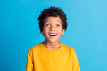 Photo of nice little schoolboy look up empty space wear pullover isolated on blue color background