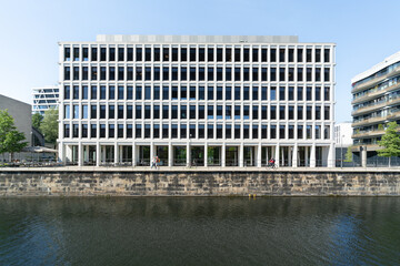Geb&auml;ude mit wei&szlig;er Fassade am Flussufer, Berlin Europacity, Lochfassade mit hohen, schmalen Fenster