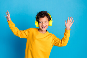 Photo portrait of adorable little boy earphones listen music dance dressed stylish yellow garment isolated on blue color background