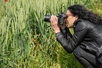 Fototapeta premium femme photographe faisant des photos de champs de blé vert au printemps 