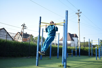 Fototapeta premium A dedicated young athlete puts in the hard work, vigorously training on gym equipment outdoors to prepare his body. He builds strength and endurance before hitting the field or court for competition