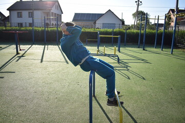 A dedicated young athlete puts in the hard work, vigorously training on gym equipment outdoors to...