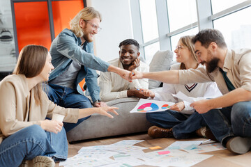 Diverse team giving fist bump celebrating successful project