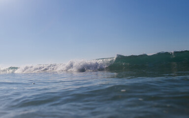 Small wave breaking on the beach shore.