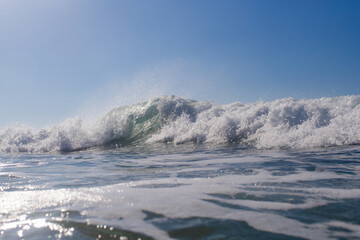 Breaking wave on the ocean on a sunny day.