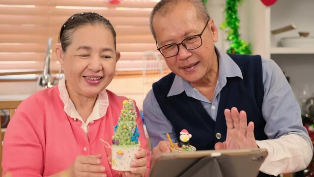 Happy Asian family spending times to prepare Chritsmas and Happy news year Celebrete. kids parent and grandparent doing ginger breads and bakery enjoy and dancing in kichen at home