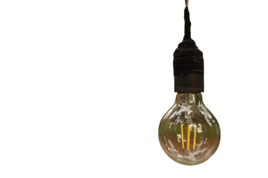 A light bulb is hanging from a black background. The light bulb is turned on and is illuminating the area around it. The light bulb is the main focus of the image.