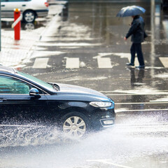 Car driving through puddle, fast driving on wet road during rain, splashing water, dangers of...