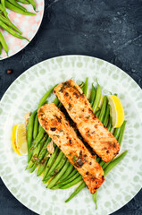 Piece of baked salmon garnished with vegetables.