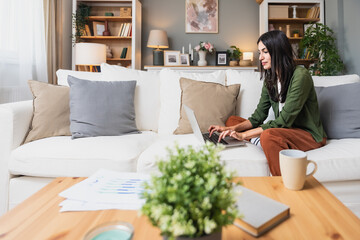 Young introvert freelancer businesswoman with ADHD working remotely from home office on laptop...