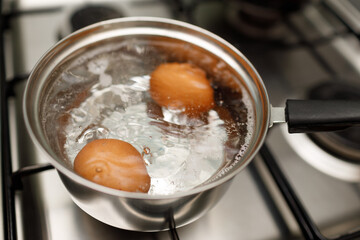 Saucepan stainless steel with boiling eggs breakfast in a water on a gas stove.