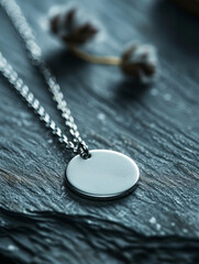 Silver pendant necklace on textured surface with soft background.