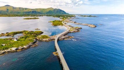Aerial view of winding road over turquoise waters along Norways coastline, connecting small islands in a picturesque route through a stunning landscape. Atlantic Ocean Road Norway © Fokke Baarssen