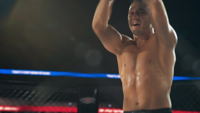 Referee Declares the Victor in a Thrilling MMA Bout Between Two Determined Male Fighters. The Winning Fighter Raising His Hands in Triumph, Acknowledging the Roaring Cheers of the Passionate Audience
