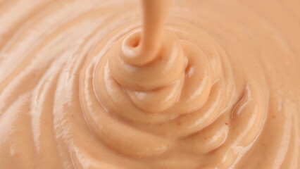 Pink sauce mayonnaise and ketchup pouring in plate, close up