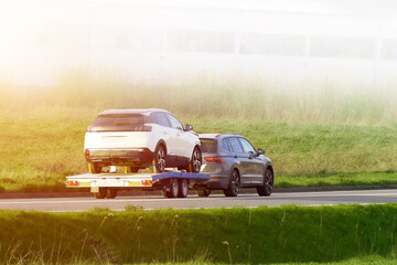 Tow truck transporting disabled car on highway