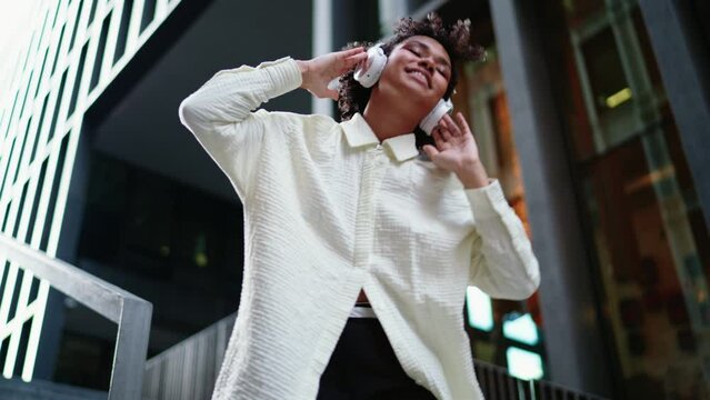 Young woman enjoying music through headphones, smiling and immersed in sound in modern city. Her relaxed, stylish look captures the essence of urban lifestyle and the joy of personal music moments
 - Powered by Adobe