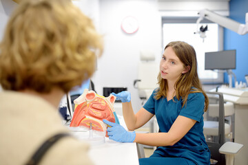 The otolaryngologist explains to the patient about his illness at the appointment. A professional...