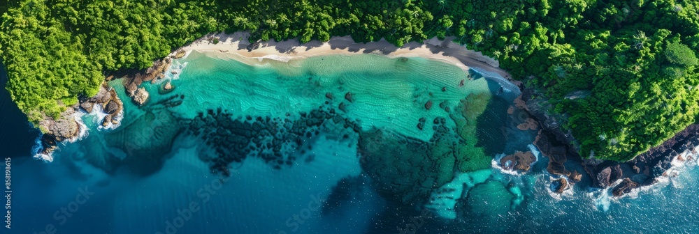 Wall mural Aerial view of a pristine, secluded bay with crystal clear waters, lush greenery, and a sandy beach - Wall murals