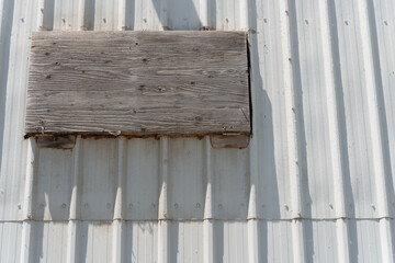 historic warehouse exterior wall with sheet metal cladding and plywood cover