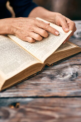 Naklejka premium Hands, person and reading bible with religion, praise and gratitude with faith, spiritual and home. Closeup, believer and follower with holy book, guidance and personal growth with worship and peace