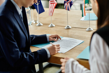 Two teenagers participate in a UN Model conference, signing a contract.