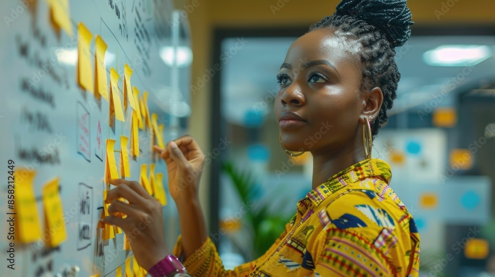 Poster diverse team of african professionals collaborating and brainstorming new ideas using sticky notes o