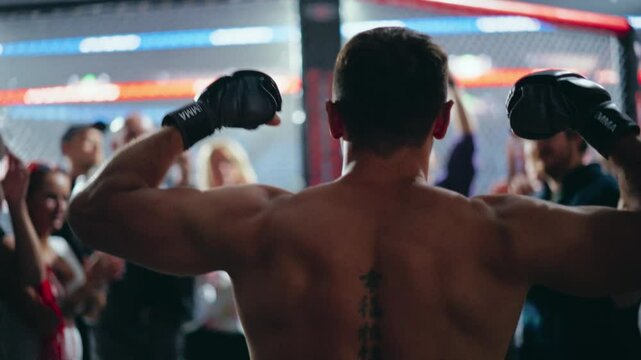 Mixed Martial Artist Entering the Arena to a Standing Ovation in the Sport Complex. Fans Applauding and Cheering for Their Favorite Fighter. Athlete Flexing His Muscles as He Walks Towards Octagon