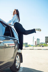 A girl sits on a car wheel.