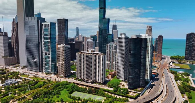 Beautiful green park below the row of a stunning modern architecture. Approaching the gorgeous buildings in the downtown of Chicago, Illinois, the USA.