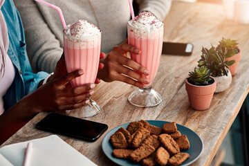 Hands, milkshake and women relax at cafe outdoor for healthy drink, bonding and eating cookies on lunch date. People, smooth and food with phone, breakfast or ice cream dessert together at restaurant