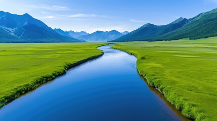 Scenic river flowing through lush green valley surrounded by mountains under clear blue sky.