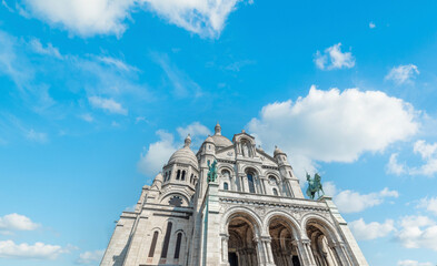 World famous Sacre Coeur cathedral under a blue sky with clouds