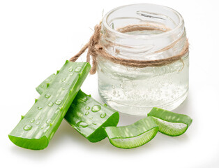 Glass jar with fresh aloe Vera inner gel and aloe vera cuts near it isolated on white background.