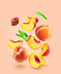 Red peaches, juicy peach slices, leaves and peach stone flying in air on pink background. File contains clipping paths.