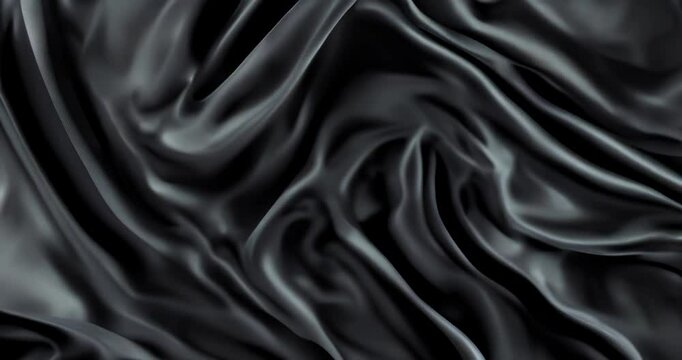 Luxurious black silk fabric waves creating elegant slow motion background