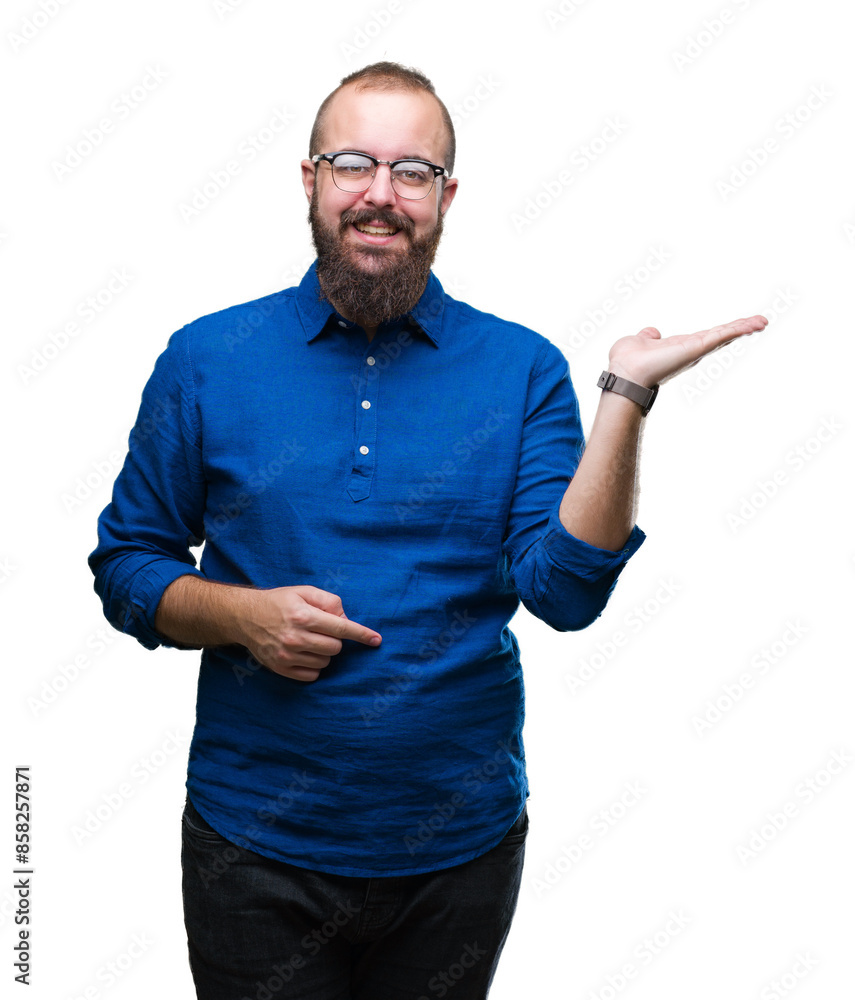 Sticker Young caucasian hipster man wearing glasses over isolated background smiling cheerful presenting and pointing with palm of hand looking at the camera.